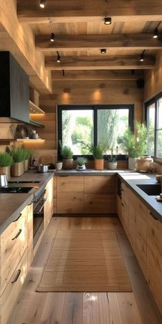 a kitchen with wooden walls and flooring next to a window filled with potted plants