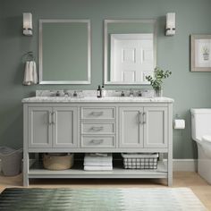 a bathroom with two sinks, mirrors and a rug on the floor in front of it