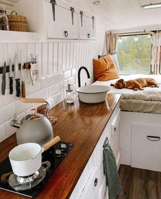 a kitchen with a stove top oven sitting next to a counter filled with cooking utensils