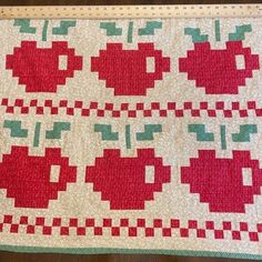 an apple quilt is displayed on a table