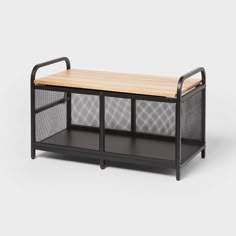 an iron and wood coffee table with mesh baskets on the top, against a white background