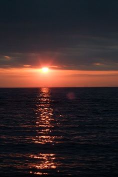 the sun is setting over the ocean as it reflects in the water's surface