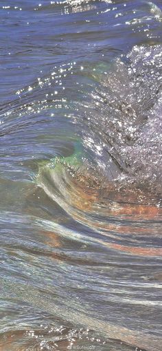 an ocean wave with small white bubbles coming from it