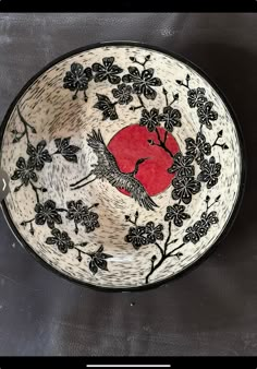 a black and white bowl with an apple in the center on a gray background, surrounded by flowers