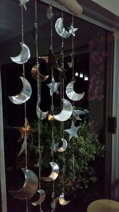 a wind chime hanging from the ceiling in front of a window with stars and crescents on it