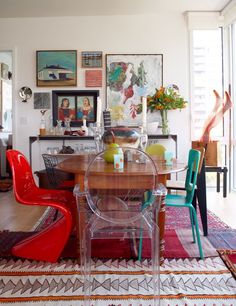 a dining room table with chairs and pictures on the wall in the backround