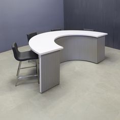 an office desk with two chairs and a curved counter top in front of a gray wall