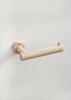 a close up of a wooden handle on a white wall with a light colored background