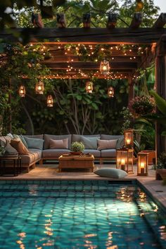 an outdoor living area is lit up with candles and lights, along with couches