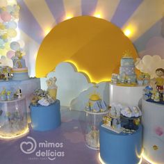 there are many cakes on display in the room with yellow and blue balloons behind them