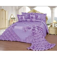 a bed with purple sheets and pillows in a room