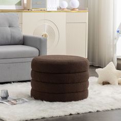 a living room with a couch, chair and ottoman next to a white rug on the floor