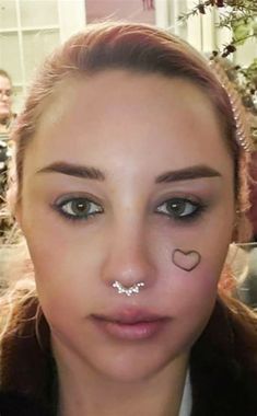 a woman with nose piercings on her nose