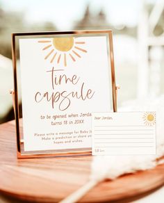 a wooden table topped with a white sign and a brown tray filled with paper on top of it