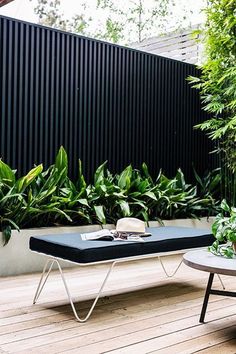 a table with a hat and sunglasses on it sitting next to some potted plants