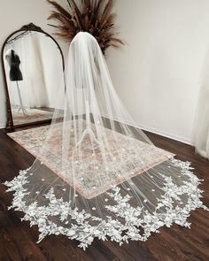 a wedding veil sits on the floor in front of a mirror