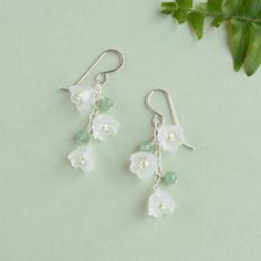 Our lily of the valley earrings will bloom all year.  Featuring creamy pearls encased in frosted white flowers, that dangle from sterling silver earrings.  The whimsical flowers are joined by green aventurine gemstones adding a touch of natural beauty.  Symbolizing sweetness and purity, the lily of the valley signifies a return to happiness.  Making the earrings a thoughtful and unique gift for a loved one, especially those with a fondness for the May birth month flower or nature-inspired jewelry.  The spring and summer earrings are also popular with those wearing cottagecore and fairycore styles. The sterling silver construction ensures durability and longevity, while the green aventurine gemstones give any outfit a pop of color.  The lily of the valley earrings are lightweight and 1¾ inc May Birth Month Flower, Fairycore Jewelry, May Birth Flower, May Birth Flowers, Anting Manik, Whimsical Flowers, Summer Earring, Nature Inspired Jewelry, Jewelry Lookbook