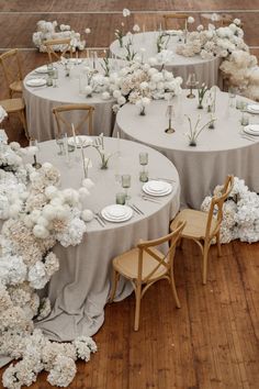 the tables are set with white flowers and place settings