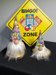 two gnomes are standing next to a sign that says bingo zone on it