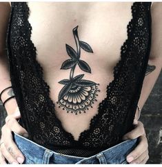 a woman's stomach with a tattoo on her chest and an image of a flower