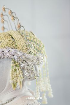 a woman's head is adorned with pearls and beads, including an elaborate hair comb