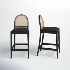 two black and white chairs sitting next to each other on top of a white floor