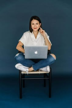 a woman sitting on a chair with her laptop