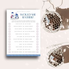 a pair of disco ball earrings sitting on top of a white table next to a checklist