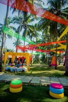 colorfully decorated tables and chairs under palm trees