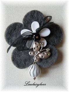 a black and white brooch with flowers on it