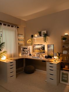 a home office with two desks and plants on the shelves in front of the window