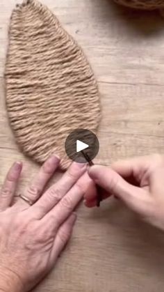 two hands touching each other on a wooden table with yarn and scissors in the background