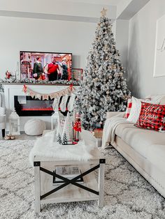 a living room with a christmas tree in the corner and presents on the coffee table