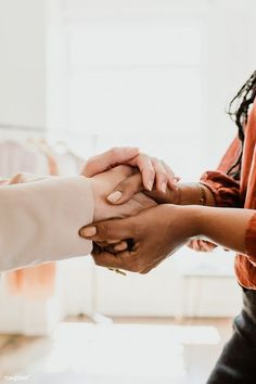 several people are holding hands together in a circle with their hands on top of each other