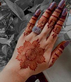 a woman's hand with henna on it and a ring in the middle