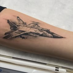 a black and white photo of a fighter jet tattoo