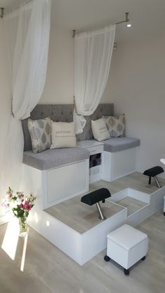 a living room with white furniture and curtains