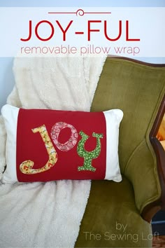 the joy pillow is on top of a green chair with a red and white pillow