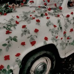 an old white car with red flowers on it