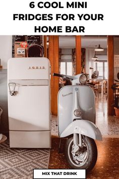 Vintage mini fridge next to a classic scooter inside a cozy home bar setting with warm lighting. Cool Mini Fridge, Home Bar Setup, Mini Fridge With Freezer, Compact Fridge, Bar Setup, Beverage Refrigerator, Small Fridges