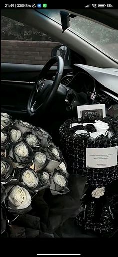 the interior of a car is decorated with white roses and black ribbon wrapped in paper