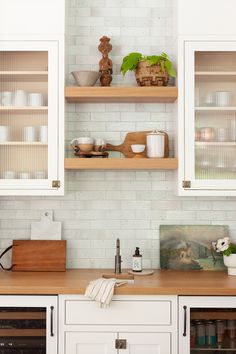 the kitchen is clean and ready for us to use it's shelves are filled with dishes