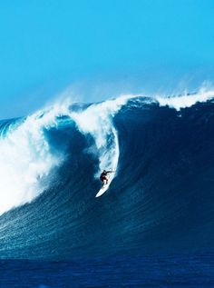 a man riding a wave on top of a surfboard in the middle of the ocean