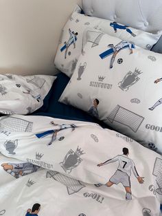 a bed with soccer themed sheets and pillows