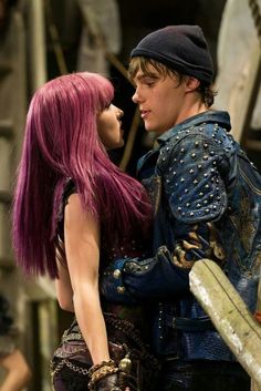 a man and woman dressed in costumes standing next to each other with purple hair on their heads