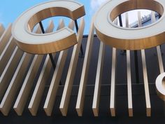 two circular mirrors on the side of a building that says q and o in gold letters