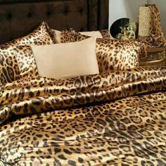 a leopard print comforter and pillows on a bed