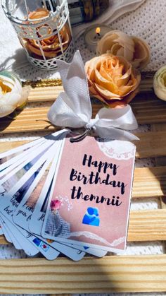 a birthday card sitting on top of a wooden table next to other cards and flowers