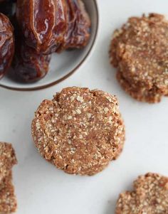 cookies and dates on a white surface with a bowl of raisins in the background