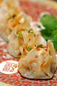 some food is sitting on a red and white plate with green garnishes